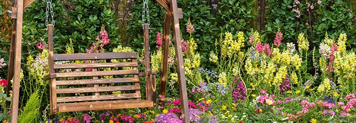 Holzschaukel im Blumengarten